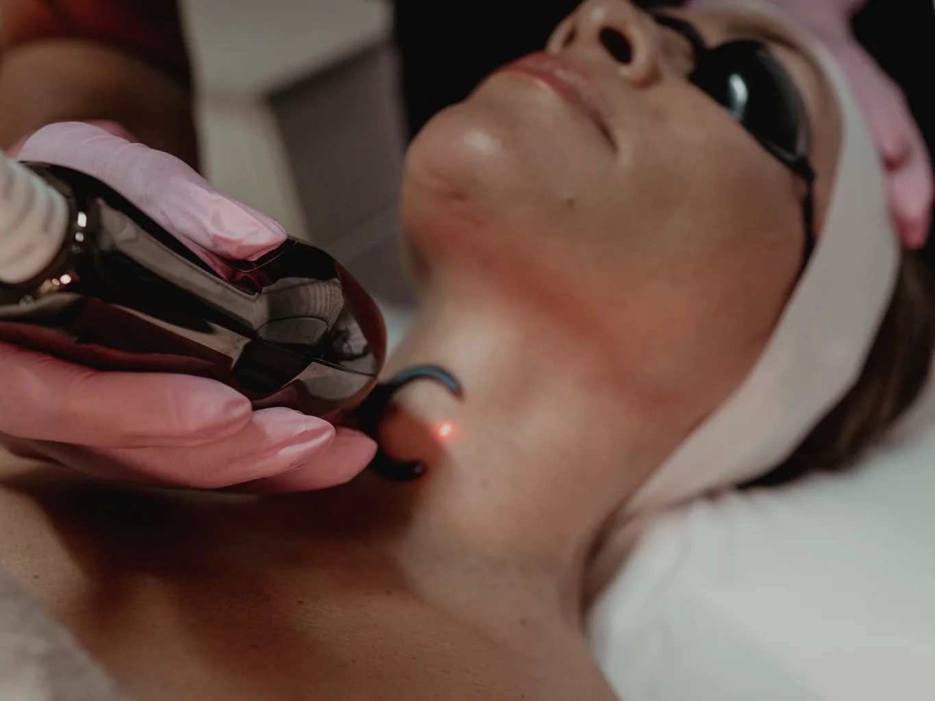 GoWell specialist treating a client's chin with a handheld device in Coral Springs
